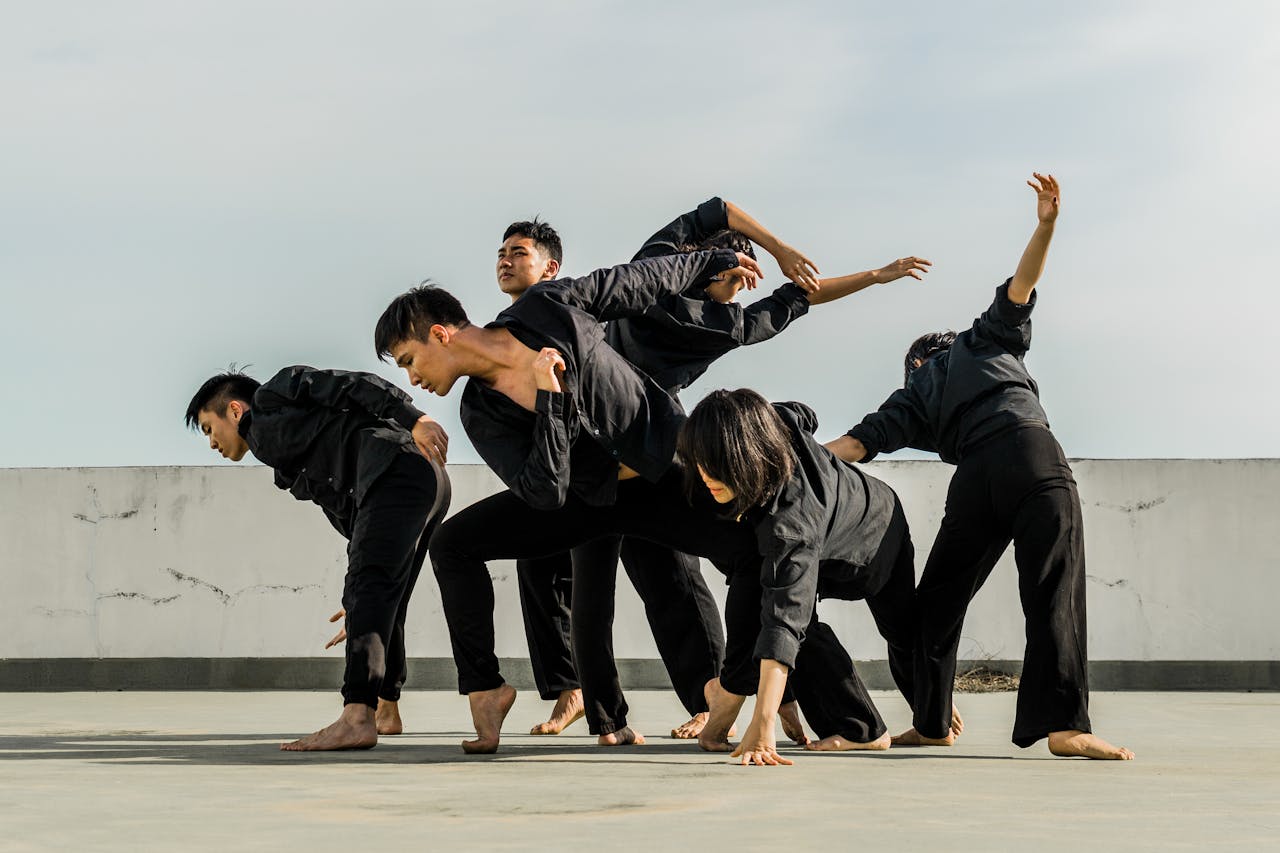 A group of adults performing dynamic contemporary dance on a rooftop.